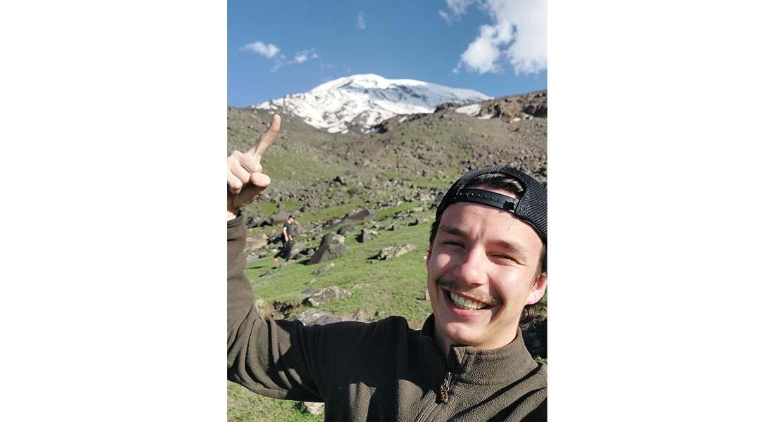 Homme devant un montagne avec un sommet blanc