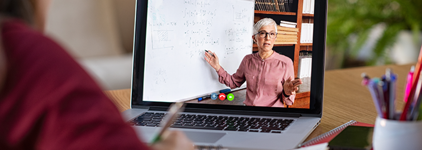 une étudiante devant un cours en ligne